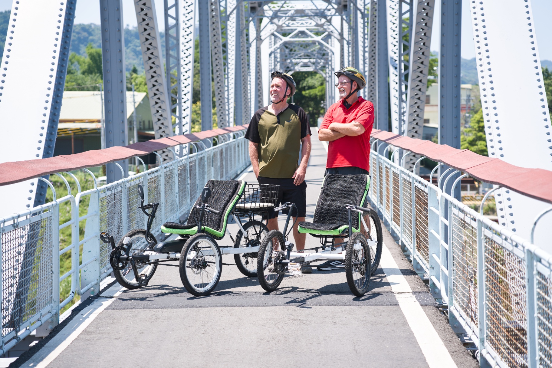 Two OVELOX trikes and riders parked on a bridge, showing stable footing